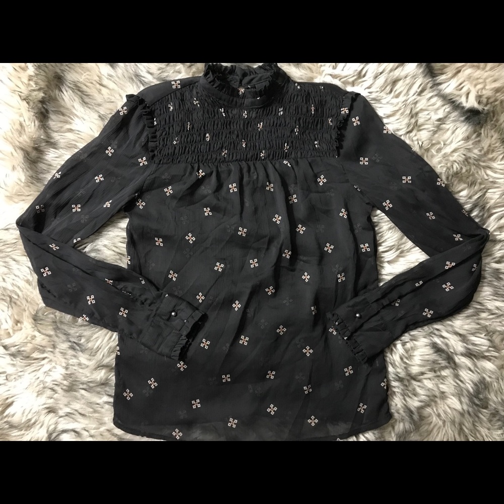 High-Neck sheer blouse with ruffle detailing.